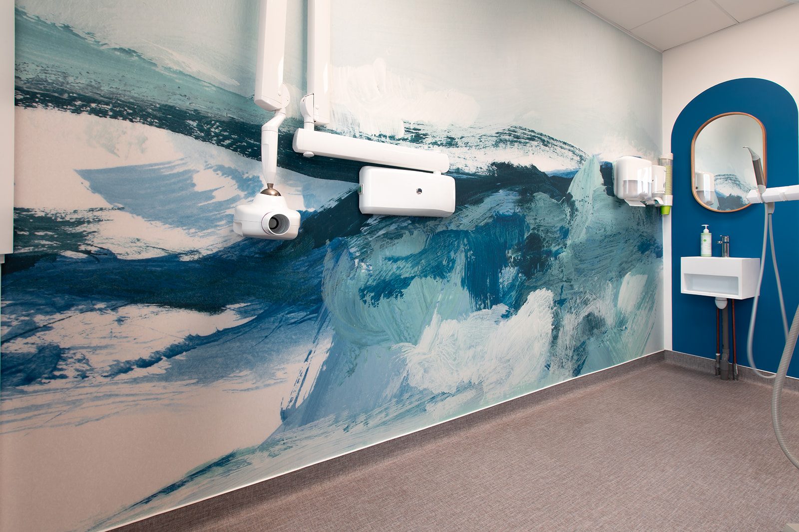 Salle de soins avec fresque vague bleue et lavabo
