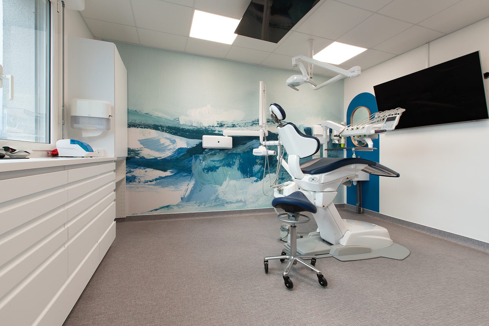 Salle de soins avec fresque artistique bleue
